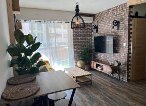 a living room with a brick wall with a tv at Vacances in Cavalaire-sur-Mer