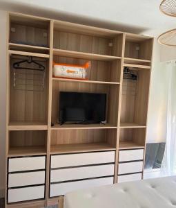 a book shelf with a tv in a bedroom at Vacances in Cavalaire-sur-Mer