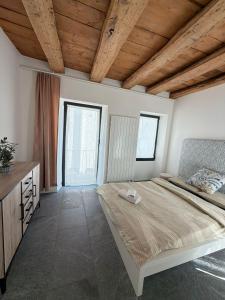 a bedroom with a large bed and two windows at La Porta Segreta del Rustico in Gordola