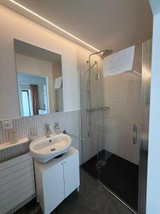 a white bathroom with a sink and a shower at La Porta Segreta del Rustico in Gordola