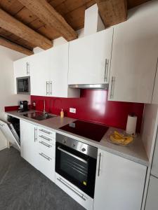 a kitchen with white cabinets and a stove top oven at La Porta Segreta del Rustico in Gordola +5 photos