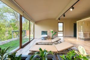 a living room with two beds and large windows at Oria Retreat in Danilovgrad
