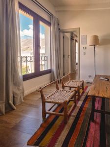a room with two chairs and a large window at Hotel El Candil Tilcara in Tilcara