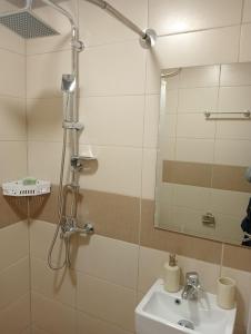 a bathroom with a shower with a sink and a mirror at Studio Panagiota in Kavála +8 photos
