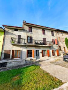 a large building with orange doors and a balcony at Alloggio DON ESTEBAN in Santa Maria della Versa