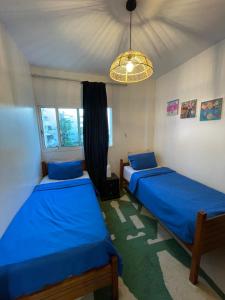 a bedroom with two beds and a chandelier at Cozy Beachfront 2BR in Rabat - Central & Secure in Rabat