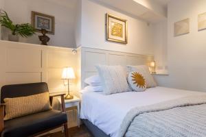 a bedroom with a white bed and a chair at Ferndale Mews in Bristol