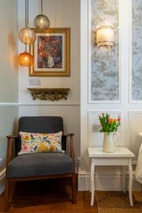 a chair and a table with a vase of flowers at Ferndale Mews in Bristol +27 photos