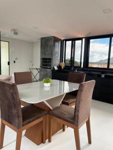 a dining room with a white table and chairs at Residencial Canto dos Passarinhos - Loft e Apartamentos in Alto Paraíso de Goiás