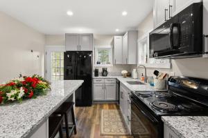 a kitchen with white cabinets and a black refrigerator at The Overlook at Orchard Hills in Bernard