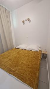 a bed in a room with a brown blanket at L'Échappée Bleue Sea view studio in Moule in Le Moule