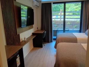 a hotel room with two beds and a flat screen tv at Hotel LUHA in Puerto Varas