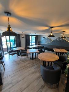 a restaurant with tables and chairs in a room at Hotel LUHA in Puerto Varas