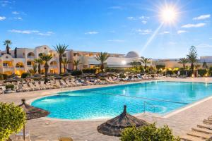 a pool with chairs and umbrellas at a resort at Djerba Aqua Resort in Midoun
