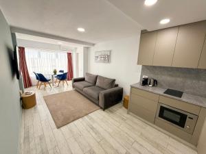a living room with a couch and a kitchen at Olimp Sea View Apartments by Maritimo in Olimp