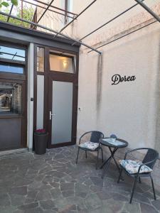 a patio with two chairs and a table in front of a door at Dorea in Jagodje