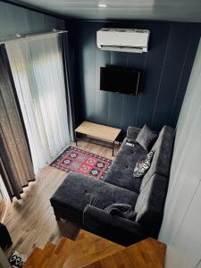 a living room with a couch and a tv at SB GREEN GARDEN in Ortaca