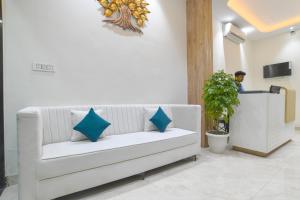 a white couch with blue pillows in a room at Aceotel Select Virat, Vijay Nagar in Indore