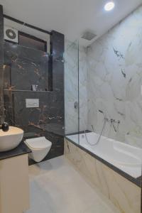 a bathroom with a tub and a toilet and a sink at Aceotel Select Virat, Vijay Nagar in Indore +74 photos