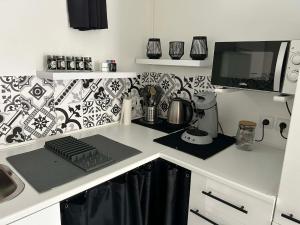 a kitchen with a counter with a keyboard and a monitor at Le studio de Louisette in Châteaudun