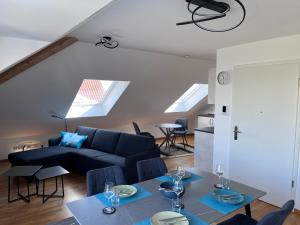 a living room with a blue couch and a table at Rooftop Apartment in Kornwestheim