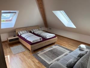 a living room with two beds and a window at Rooftop Apartment in Kornwestheim