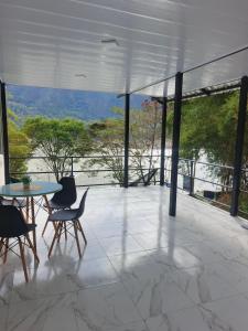 a patio with a table and chairs and a view at Cabaña La Rivera in Macanal