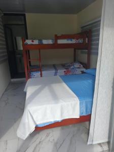 a bedroom with a wooden bunk bed with a blue comforter at Cabaña La Rivera in Macanal +7 photos