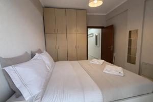 a bedroom with a large bed with white sheets and cabinets at MK Seaview Stays in Neos Marmaras