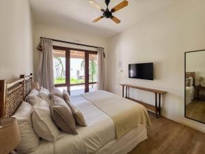 a bedroom with a bed with a ceiling fan at Hotel El Candil Tilcara in Tilcara