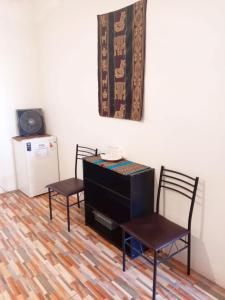 two chairs and a dresser in a room at CASA HOSTAL LA PASKANA ATACAMEÑa in San Pedro de Atacama