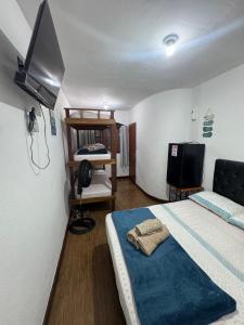 a bedroom with a bed and a tv in a room at Suítes como uma onda in Abraão