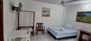 a bedroom with a bed and a chair and a desk at Heliconias Hotel in Leticia