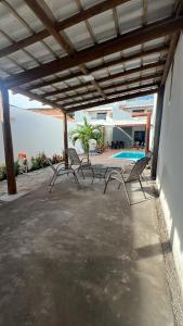 a group of chairs sitting on a patio with a pool at Temporadaemjaua in Camaçari