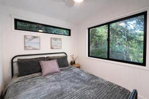 a bedroom with a bed and a large window at Wave and Willow Tiny Home in Broughton Village