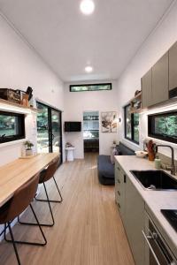 a kitchen and living room with a table and chairs at Wave and Willow Tiny Home in Broughton Village