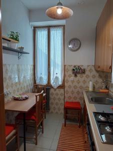 a kitchen with a table and chairs and a clock on the wall at La Yucca in Dolceacqua +11 photos