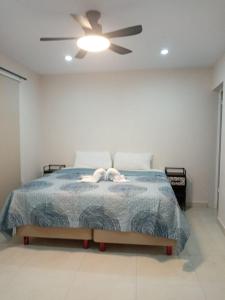 a bedroom with a bed with a ceiling fan at Hermoso apartamento nuevo in Isla Mujeres