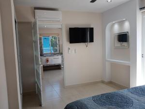 a bedroom with a bed and a television on the wall at Hermoso apartamento nuevo in Isla Mujeres