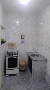 a small kitchen with a stove and a sink at Oliveira Hospedagens in Salvador