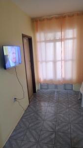 a living room with a tv on the wall at Oliveira Hospedagens in Salvador