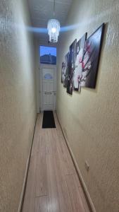 a hallway with a door and pictures on the wall at The ultimate group stay in Catford