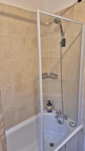 a bathroom with a shower and a bath tub at The ultimate group stay in Catford