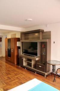 a large entertainment center with a flat screen tv at MATARA GREENS HOTEL in Cusco