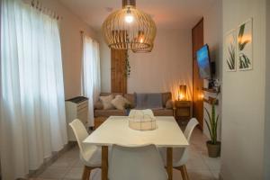 a table and chairs in a living room with a couch at Aloha Nelly - Departamento de alquiler por día in Trelew
