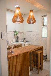 a kitchen with two hanging lights and a counter at Aloha Nelly - Departamento de alquiler por día in Trelew +79 photos