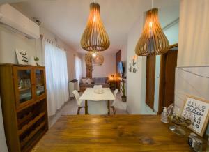 a living room with a table and two chandeliers at Aloha Nelly - Departamento de alquiler por día in Trelew