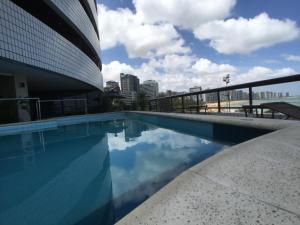 a pool on the roof of a building with a view of the city at Beira Mar Suite in Fortaleza