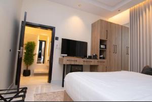 a bedroom with a bed and a flat screen tv at Princess House in Jeddah