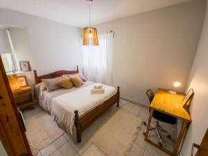 a small bedroom with a bed and a table at Aloha Nelly - Departamento de alquiler por día in Trelew